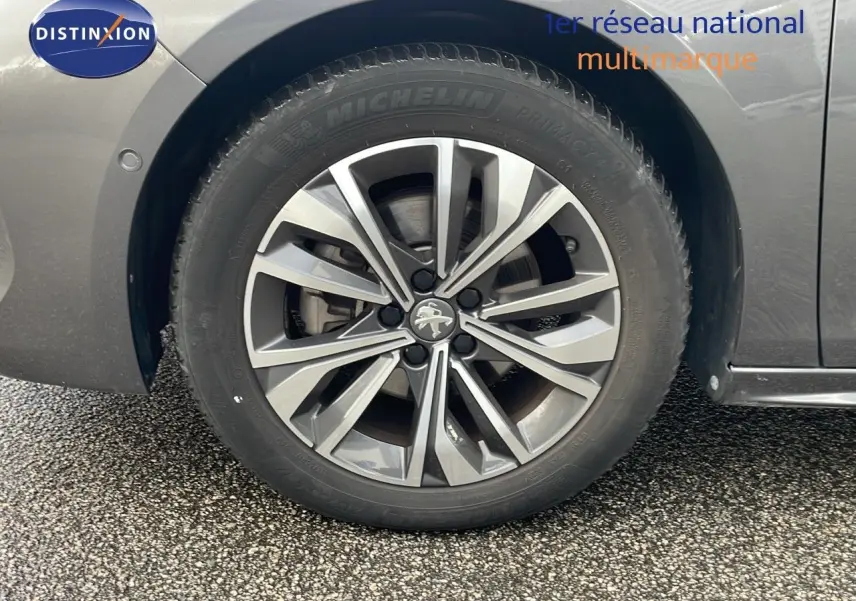 Gros plan sur la roue avant gauche de la Peugeot 508 gris platinium métal, mettant en valeur la jante alliage à design moderne.