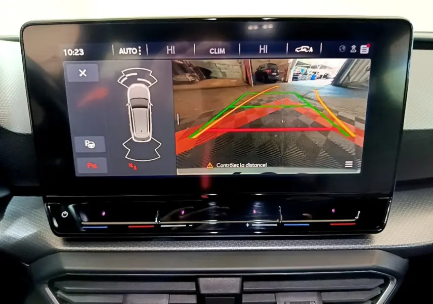Écran tactile central affichant la caméra de recul et l'aide au stationnement sur une SEAT Leon gris clair, vue intérieure.