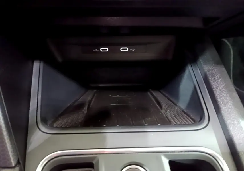 Gros plan sur la zone de recharge à induction et ports USB dans l'habitacle du SEAT Leon gris clair 2022.