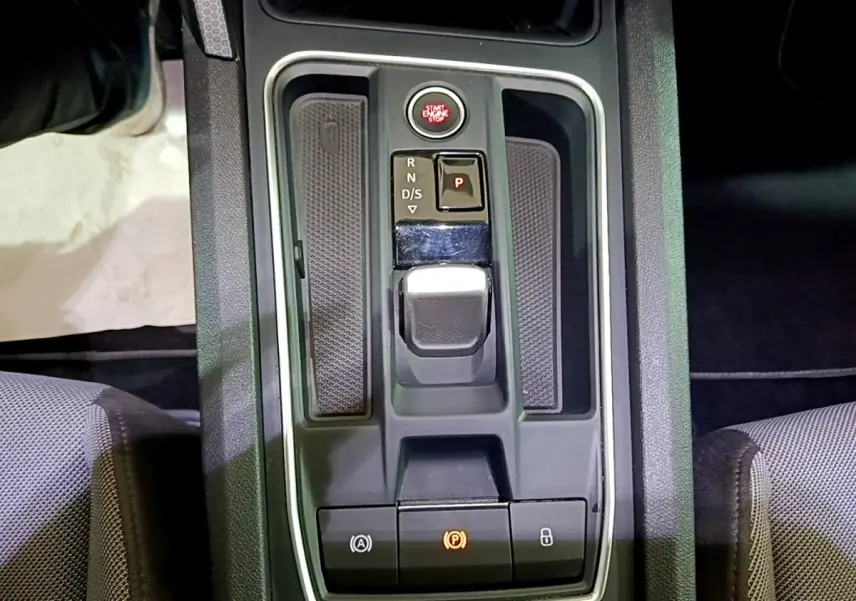 Vue plongeante sur la console centrale grise du SEAT Leon 2022 avec levier de boîte auto et bouton start/stop rouge.
