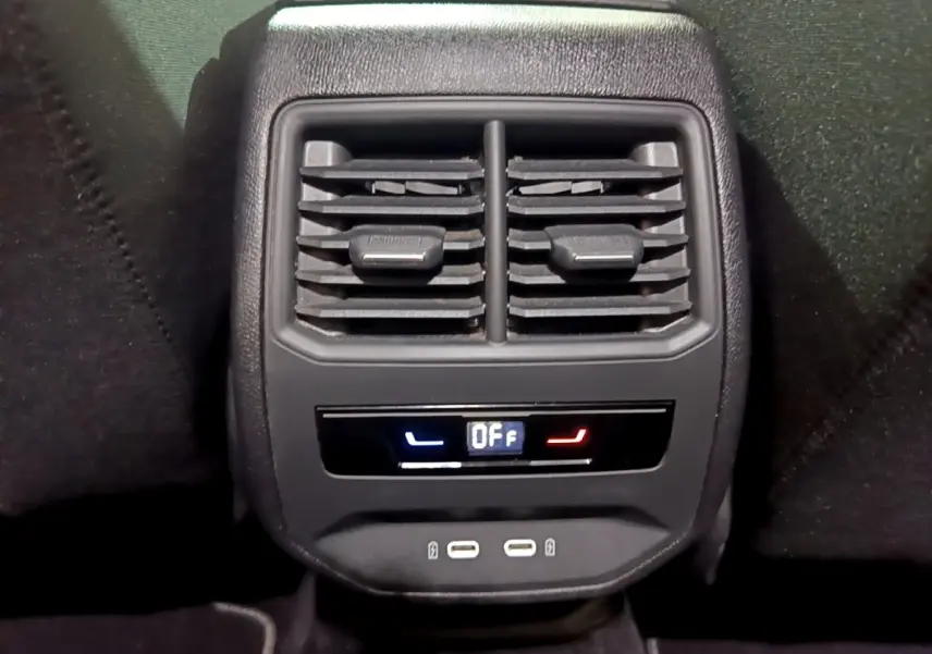 Gros plan sur la console arrière noire du SEAT LEON gris clair 2022 avec commandes climatisation et ports USB visibles