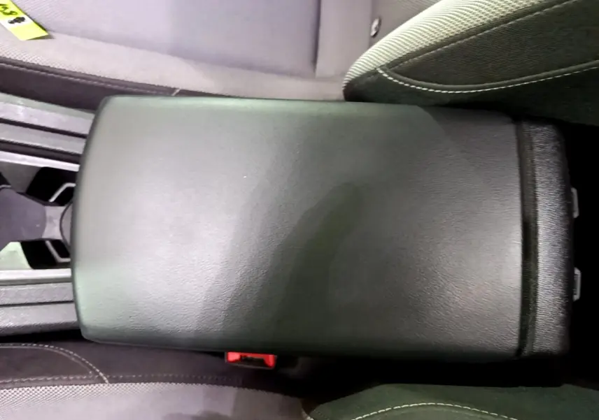 Accoudoir central noir entre les sièges avant du SEAT LEON gris clair, version 2022, vue intérieure rapprochée.