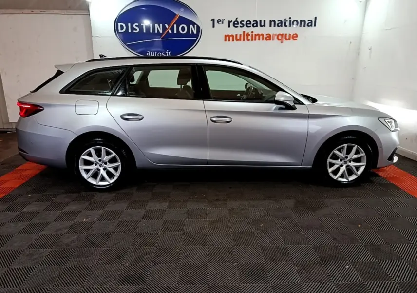 Vue latérale droite d'une SEAT LEON gris clair break 2022, stationnée en intérieur avec éclairage neutre.