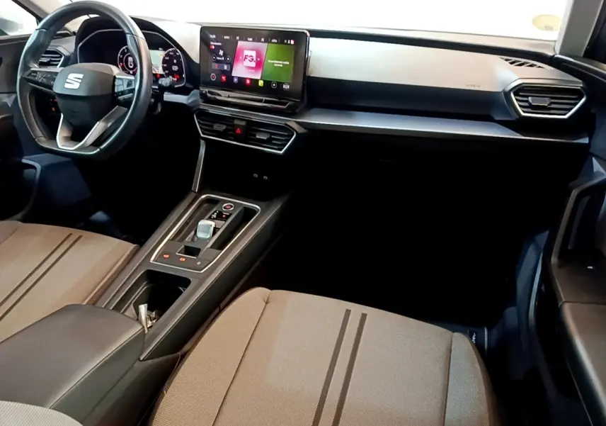 Intérieur avant de la SEAT LEON 2.0 TDI 2022, vue côté conducteur, tableau de bord noir avec écran tactile central.