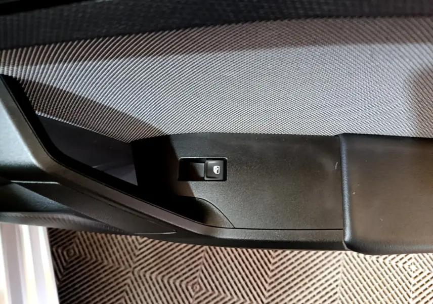 Détail de la commande de verrouillage sur la portière côté conducteur d'une SEAT LEON gris clair 2022.