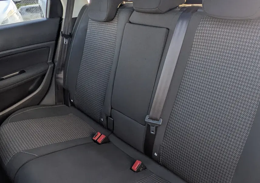 Vue intérieure arrière de la banquette noire et grise du Peugeot 308 SW avec toit panoramique ouvert.