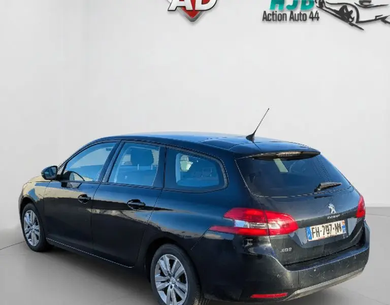 Peugeot 308 SW noire vue en 3/4 arrière droit, avec feux arrière LED et jantes alliage visibles.
