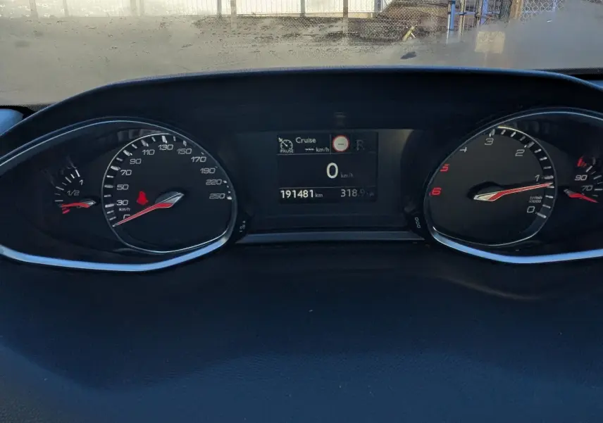 Vue intérieure du tableau de bord de la Peugeot 308 SW 2019, affichage digital et compteurs analogiques noirs.