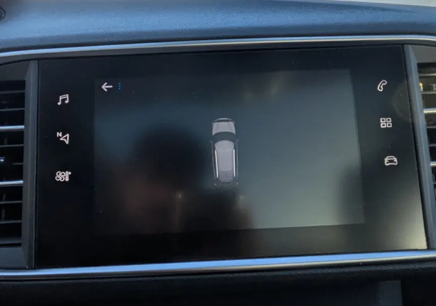 Vue rapprochée de l'écran tactile central noir affichant le système de guidage de stationnement de la Peugeot 308 SW.