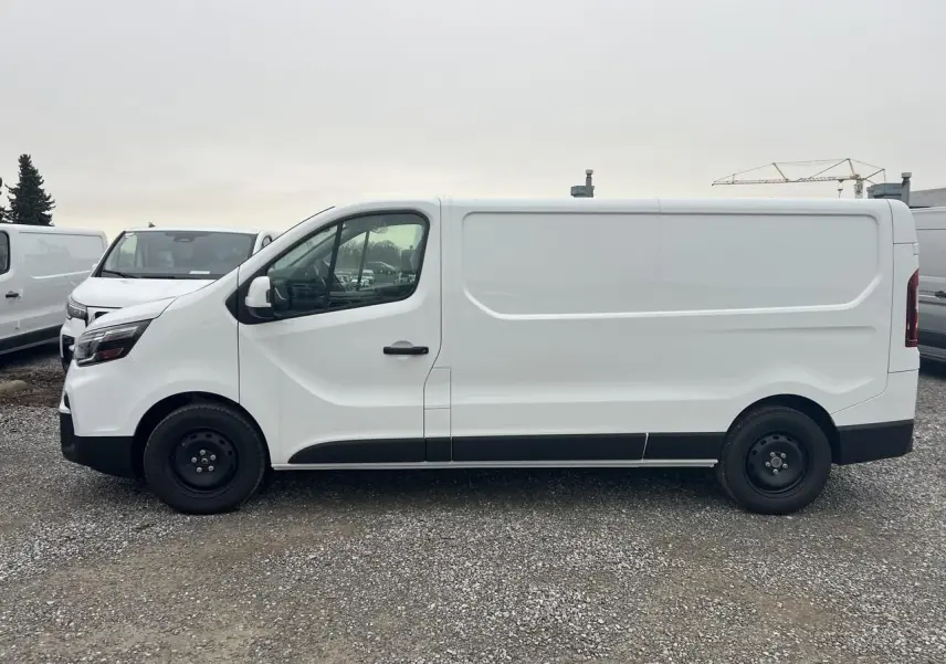 Vue 3/4 avant droite d’un utilitaire Nissan Primastar blanc avec calandre noire et plaque Zero KM sur un terrain extérieur.