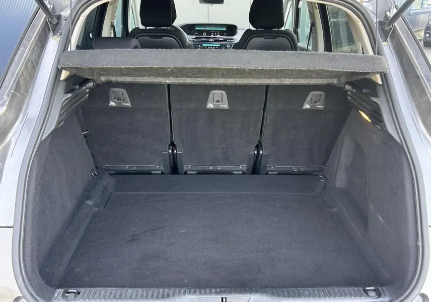 Coffre ouvert vu de l'arrière d'une Citroën C4 Spacetourer gris Platinium avec banquette arrière en tissu noir.