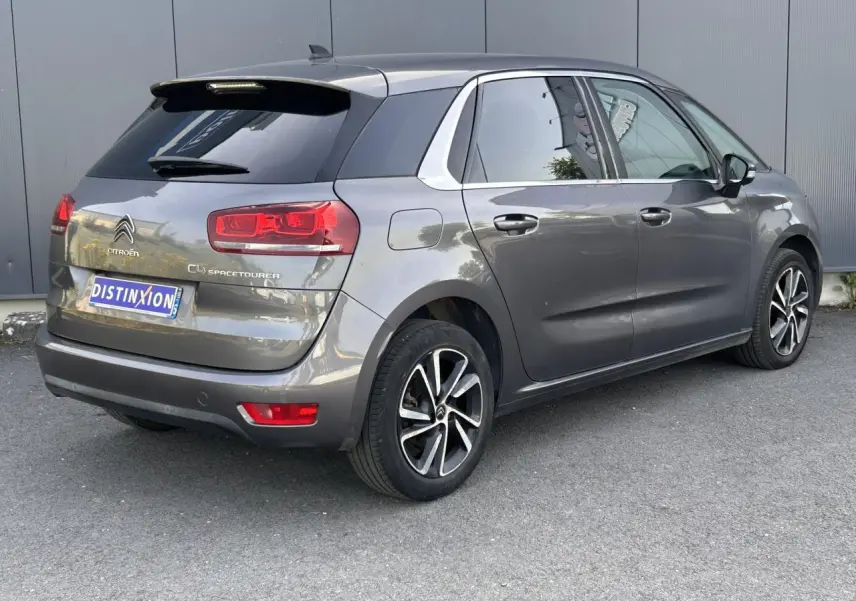 Vue 3/4 arrière droit d'une Citroën C4 Spacetourer gris Platinium avec jantes alliage bi-ton et vitres surteintées.