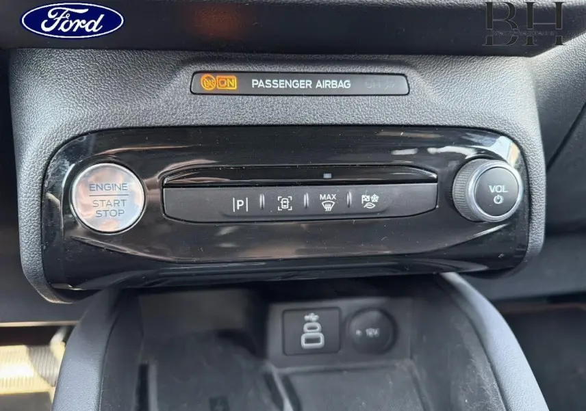 Détail de la console centrale du Ford Kuga 2025, bouton start/stop, commandes de stationnement et volume, finition noire brillante.