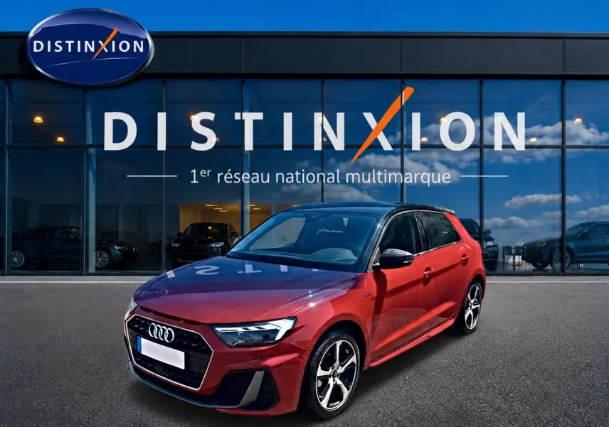 Audi A1 Sportback rouge et noir vue 3/4 avant droit devant un showroom Distinxion.