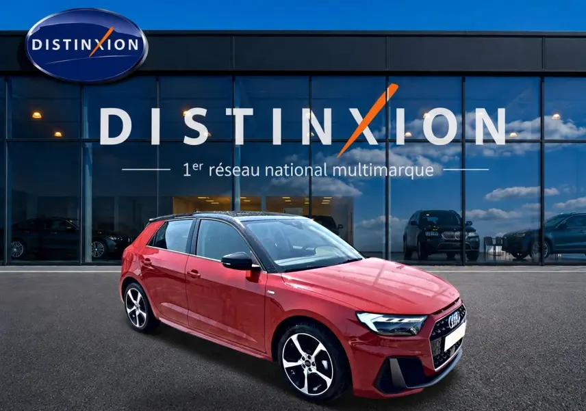 Audi A1 Sportback rouge et noir vue 3/4 avant droit, avec jantes alu et toit noir devant showroom Distinxion.
