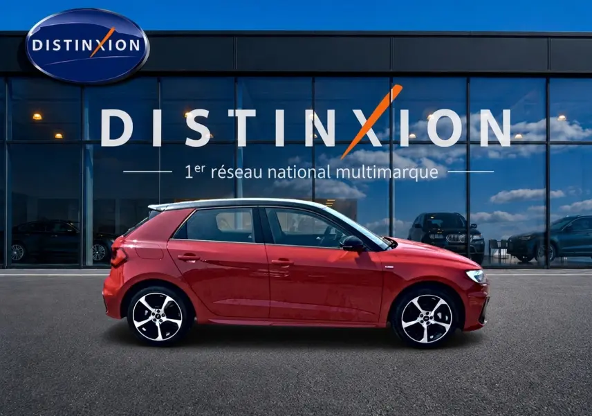 Audi A1 Sportback rouge et noir vue de profil côté gauche devant une vitrine avec logo Distinxion.