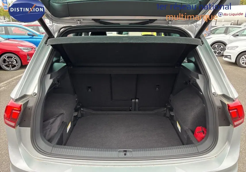 Coffre ouvert vue arrière d’un Volkswagen Tiguan 2024 Reflex Silver Metal, montrant un espace de chargement spacieux et propre.
