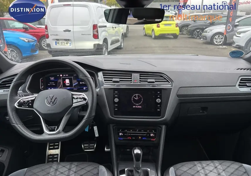 Vue intérieure frontale du Volkswagen Tiguan 1.5 TSI 150CH R-Line 2024, tableau de bord gris noir avec volant multifonction et écran tactile central.