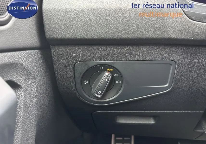 Gros plan sur le sélecteur de phares en position auto dans l’habitacle noir du Volkswagen Tiguan 2024 Reflex Silver.