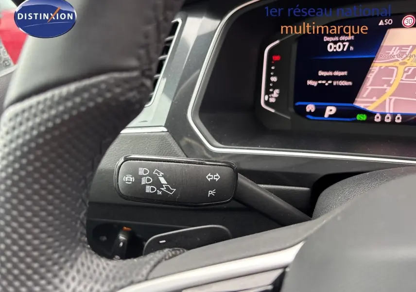 Gros plan sur le commodo gauche et le tableau de bord numérique du Volkswagen Tiguan 2024 en intérieur gris noir.