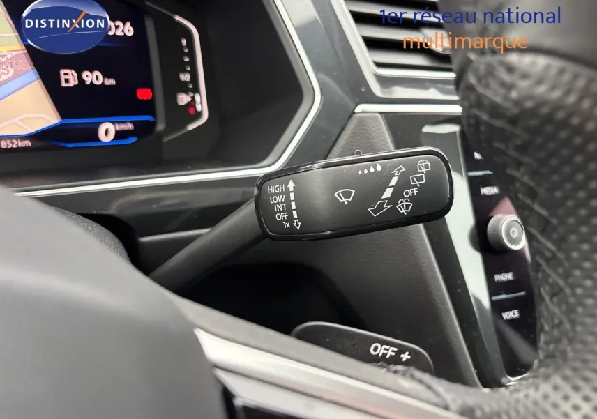 Gros plan sur la commande d’essuie-glace à gauche du volant dans l’habitacle gris noir du Volkswagen Tiguan 2024.