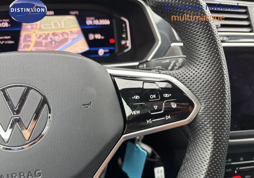 Gros plan sur le volant perforé et les commandes multifonctions d’un Volkswagen Tiguan 2024 couleur Reflex Silver Metal.
