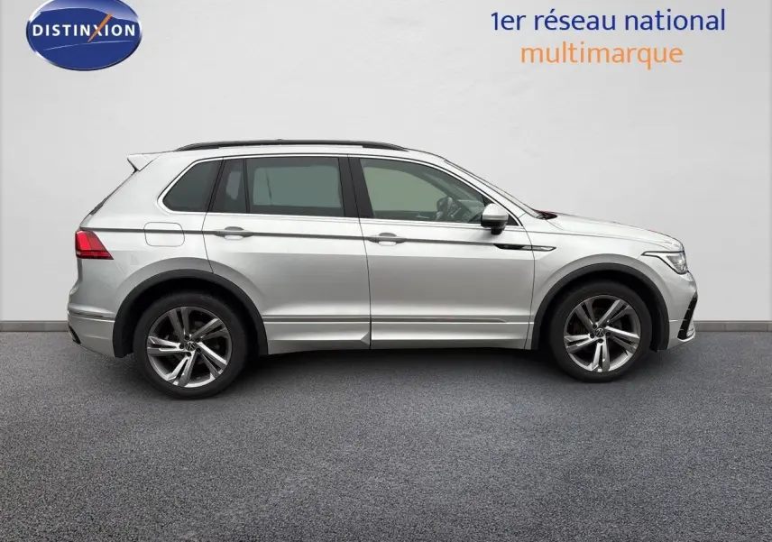 Profil droit d'un Volkswagen Tiguan 1.5 TSI R-Line 2024 en Reflex Silver Metal avec jantes alliage et détails noirs.