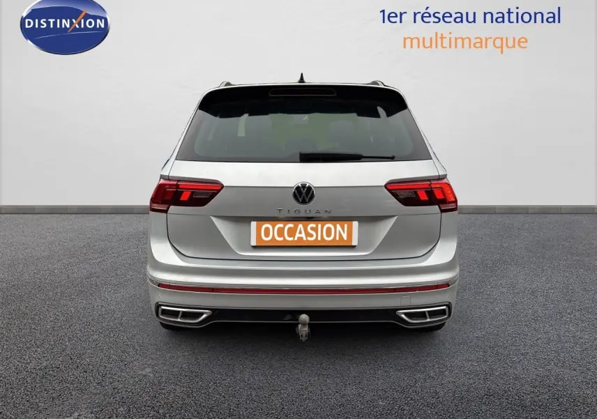 Vue arrière d'un Volkswagen Tiguan 1.5 TSI R-Line 2024 en Reflex Silver Metal avec attelage visible.