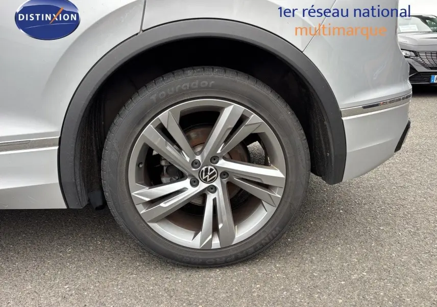 Gros plan sur la roue arrière droite d’un Volkswagen Tiguan 2024 Reflex Silver avec jante alliage R-Line.