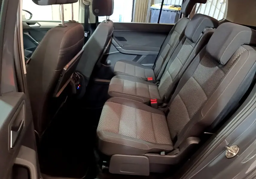 Vue intérieure côté droit des sièges arrière gris foncé du Volkswagen Touran 2023, avec appuie-têtes et ceintures visibles.