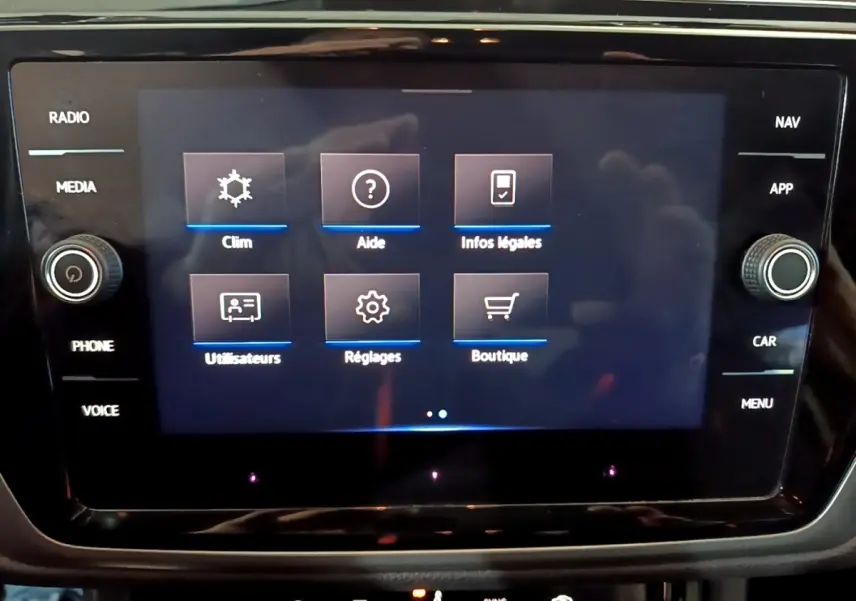 Écran tactile central du Volkswagen Touran gris foncé 2023 affichant les options climatisation, aide et réglages.
