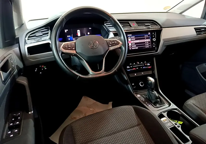 Intérieur du Volkswagen Touran 2023 vu du siège conducteur, avec tableau de bord numérique et console centrale moderne.