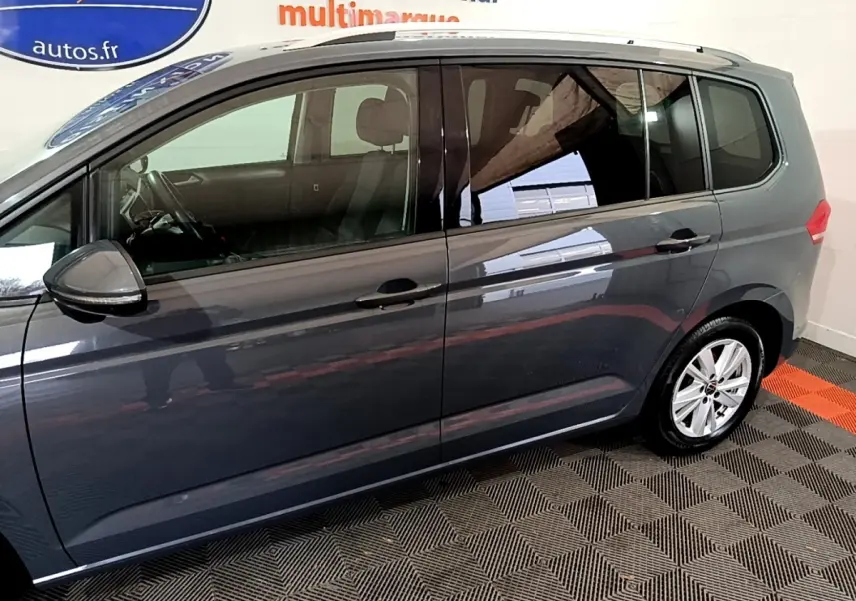 Profil côté gauche d'un Volkswagen Touran gris foncé 2023, avec jantes alliage et vitres teintées.