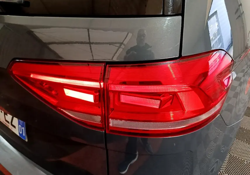 Feu arrière droit rouge sur Volkswagen Touran gris foncé 2023, vue rapprochée du coin arrière du véhicule.