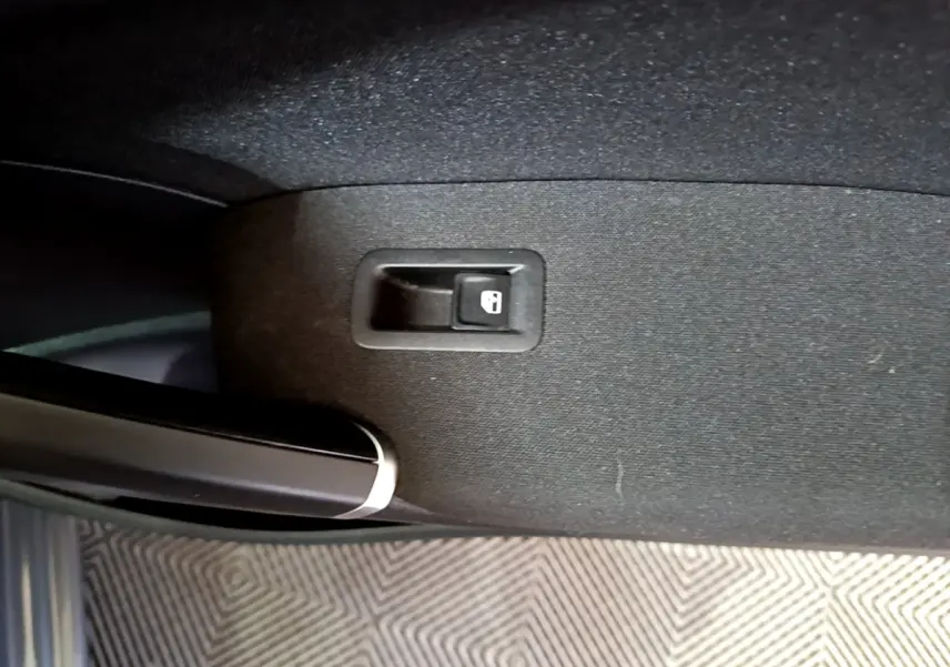 Bouton de verrouillage de porte sur la garniture intérieure côté gauche d'un Volkswagen Touran gris foncé 2023.