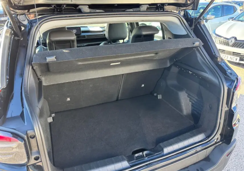 Coffre ouvert vu de l'arrière d'un Jeep Avenger noir 2024, montrant l'espace de chargement et la tablette cache-bagages.