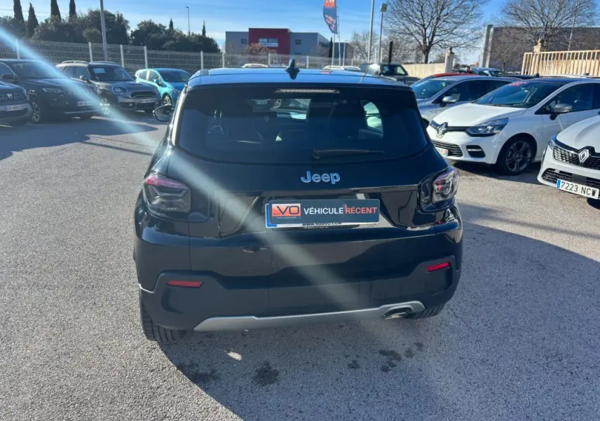 Vue arrière d'un Jeep Avenger noir 2024 garé en extérieur, avec feux arrière LED et plaque d'immatriculation visible.