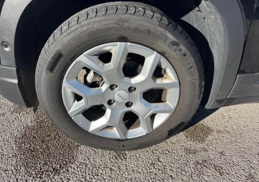 Gros plan sur la jante alliage 17 pouces argentée d’un Jeep Avenger noir, avec logo Jeep au centre.