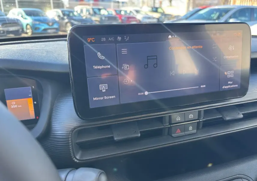 Vue intérieure du tableau de bord du Jeep Avenger 2024 noir, avec écran tactile central et commandes de climatisation.