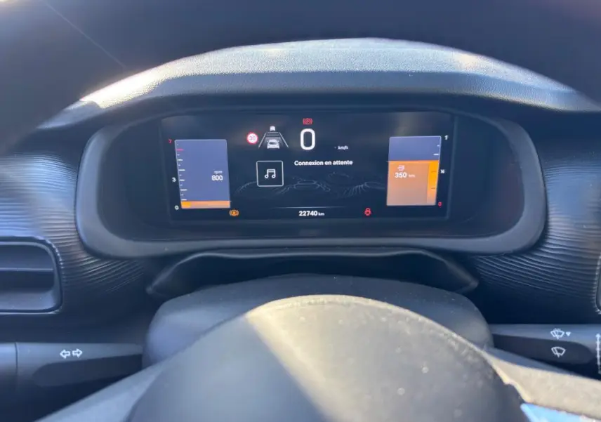 Vue rapprochée du tableau de bord numérique du Jeep Avenger noir 2024, affichant la vitesse et les alertes.