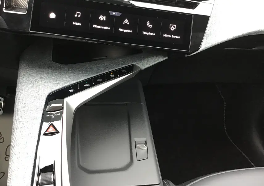 Vue intérieure du Peugeot 3008 2026, console centrale avec finition tissu gris clair et écran tactile noir affichant les commandes multimédia.