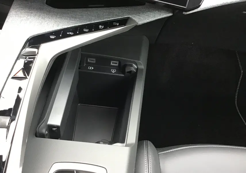 Gros plan intérieur sur la console centrale du Peugeot 3008 1.2 Hybrid 145, avec ports USB et commandes tactiles.
