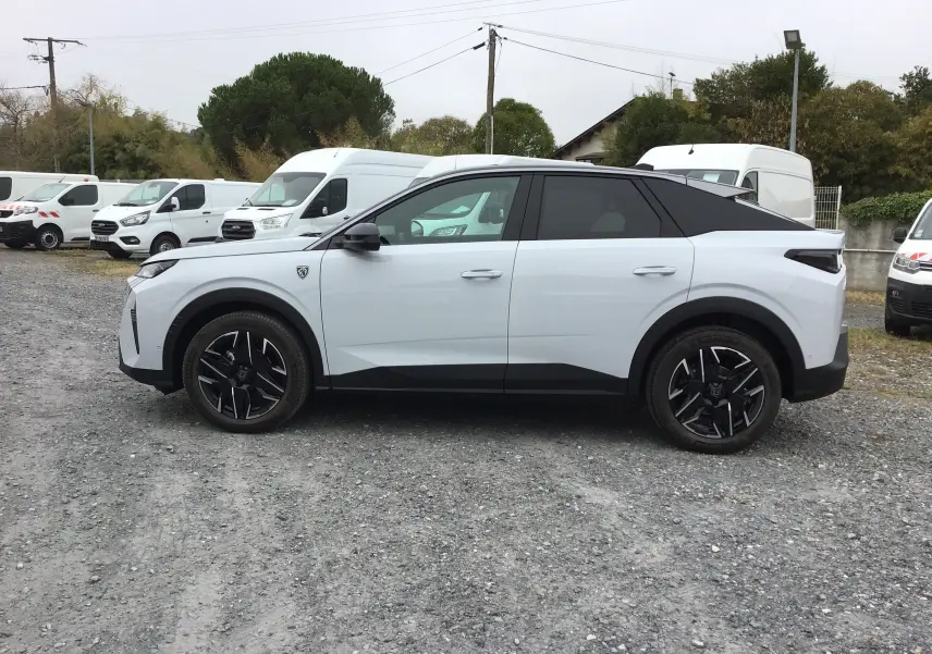 Profil droit du Peugeot 3008 blanc Okenite avec toit noir, jantes noires et détails modernes sur un sol gravillonné.