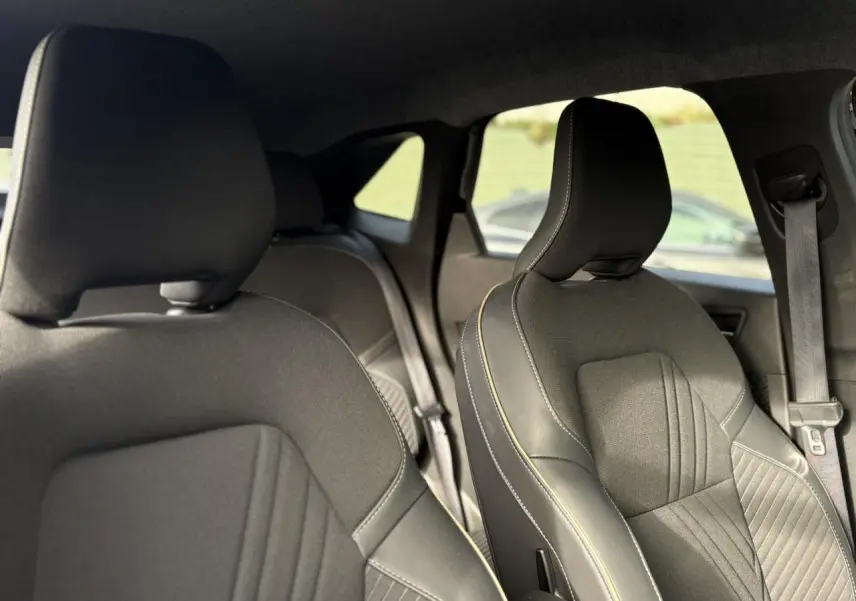Vue intérieure des sièges avant en tissu et cuir noir avec surpiqûres contrastantes dans une Renault Symbioz 2025.