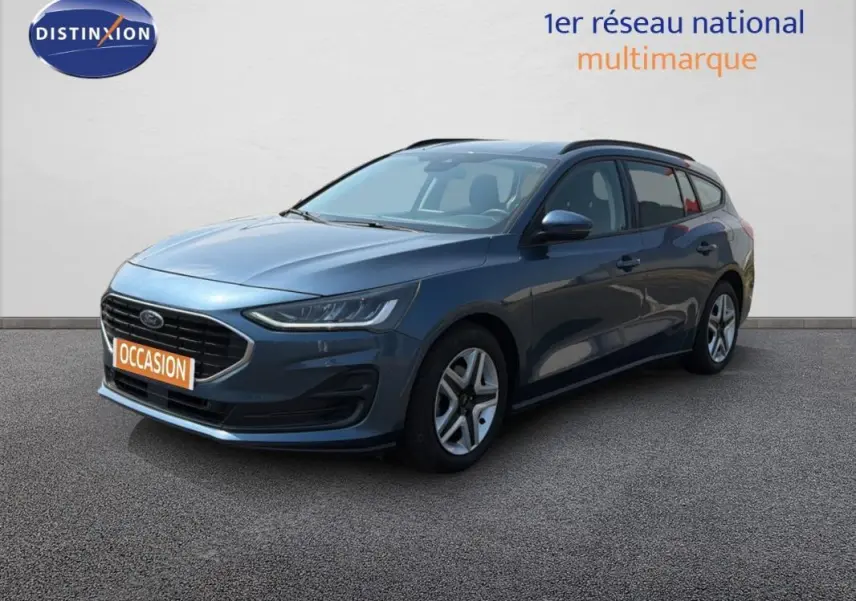 Ford Focus SW bleu foncé vue 3/4 avant droit avec barres de toit et jantes classiques 16 pouces.