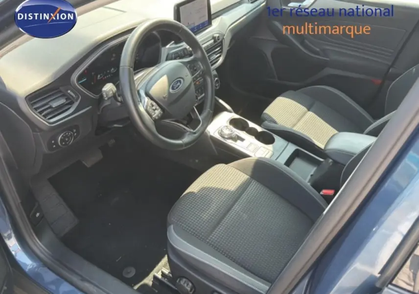 Vue intérieure côté conducteur de la Ford Focus SW 2022 bleu foncé, avec tableau de bord et console centrale moderne.