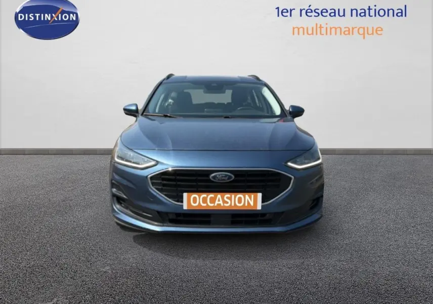 Vue frontale d'une Ford Focus SW bleu foncé 2022 avec calandre noire et phares LED allumés.