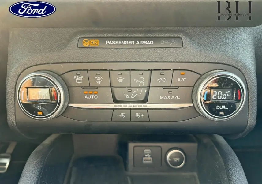 Vue rapprochée de la console centrale du Ford Kuga 2020, montrant la climatisation bi-zone et les commandes digitales.