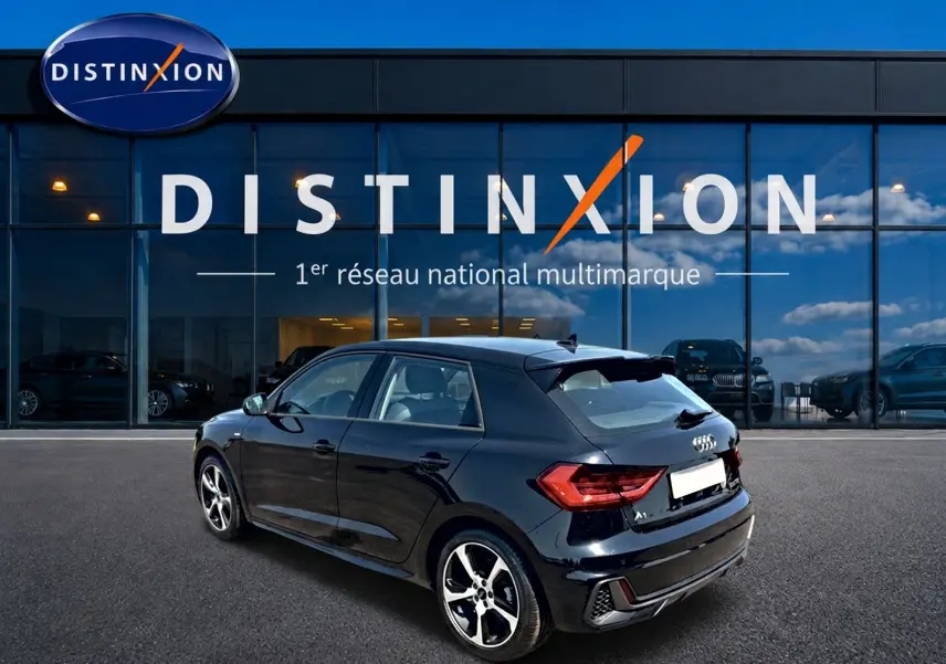 Audi A1 Sportback noir vue 3/4 arrière droit, avec jantes alliage et becquet arrière distinctif.