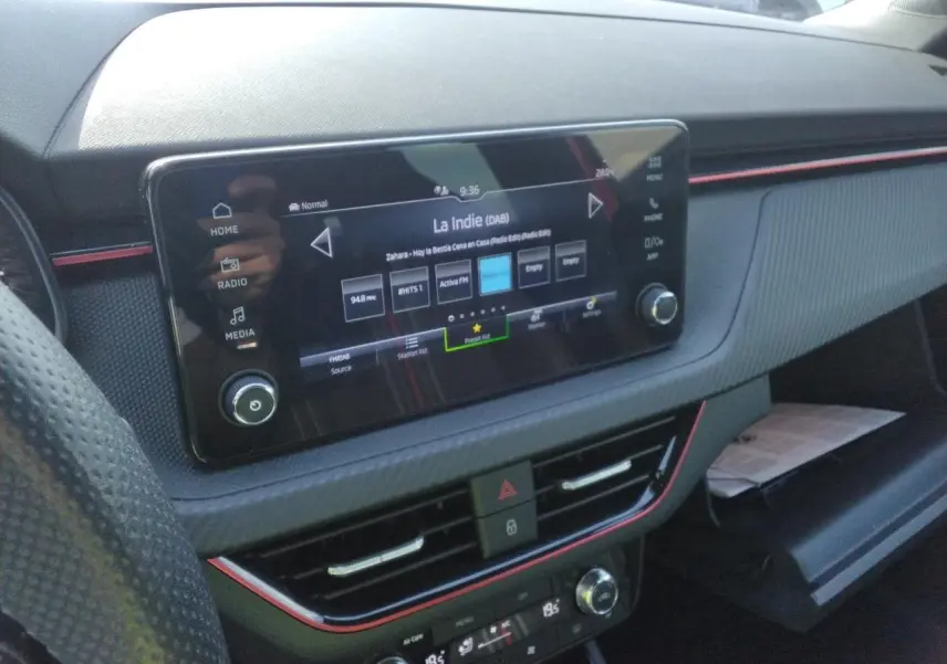 Vue rapprochée de la console centrale de la Skoda Scala Monte-Carlo 2025, avec écran tactile et inserts rouges décoratifs.